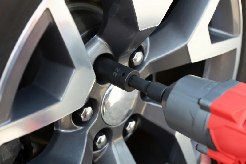 Impact wrench removing the wheel nuts on an alloy wheel